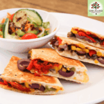 How to Perfect Toasted Pita Tramezzinis illustrated by a sliced tramezzini with a side dish