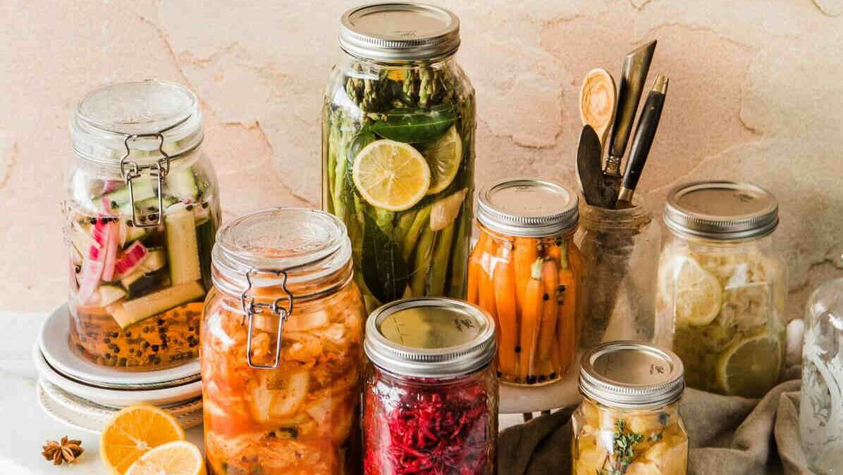 glass jars with fermenting fruit and vegetable pieces