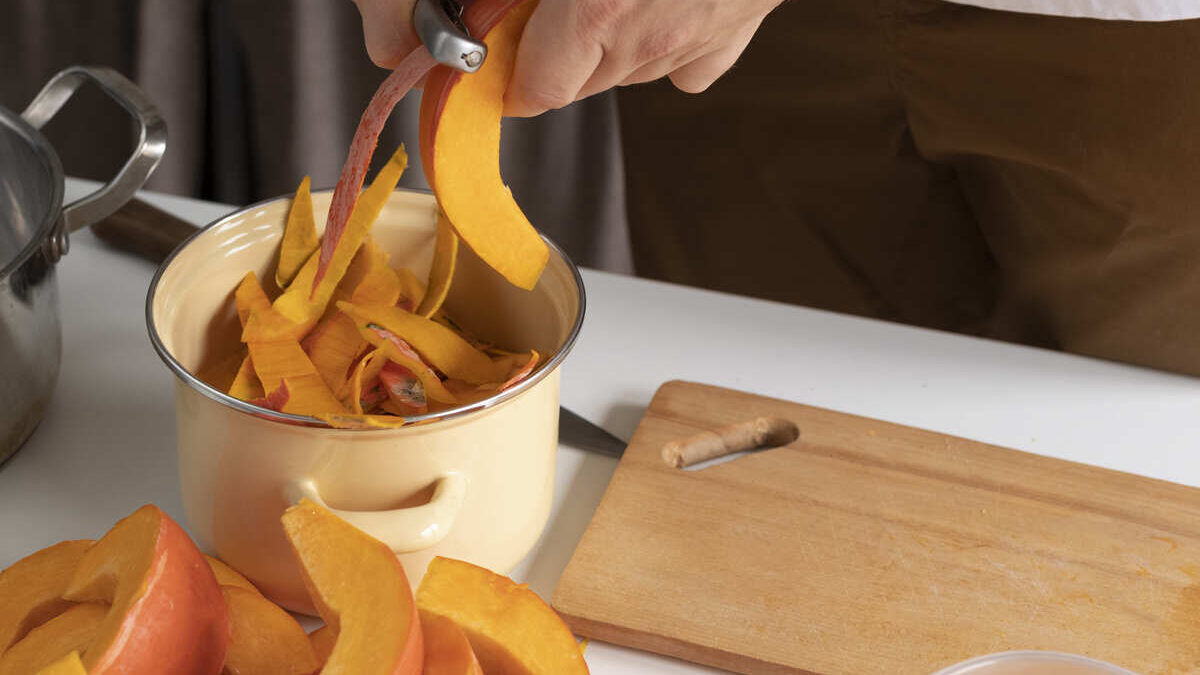 Close up of person busy peeling a vegetable slice for food preservation to depict Sustainable Kitchen Hacks
