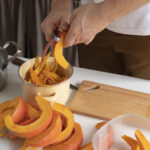 Close up of person busy peeling a vegetable slice for food preservation to depict Sustainable Kitchen Hacks