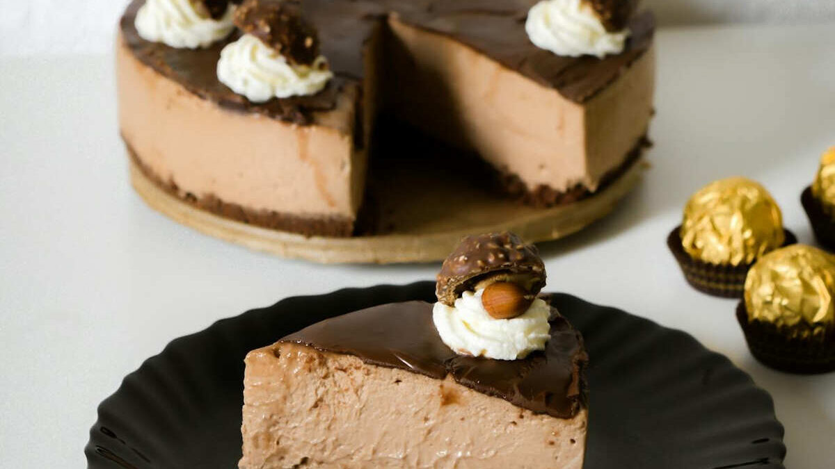 No-bake chocolate hazelnut cheesecake slice, topped with whipped cream and a Ferrero Rocher.