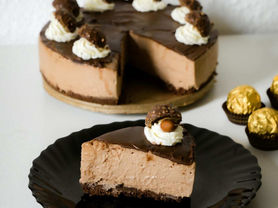 No-bake chocolate hazelnut cheesecake slice, topped with whipped cream and a Ferrero Rocher.