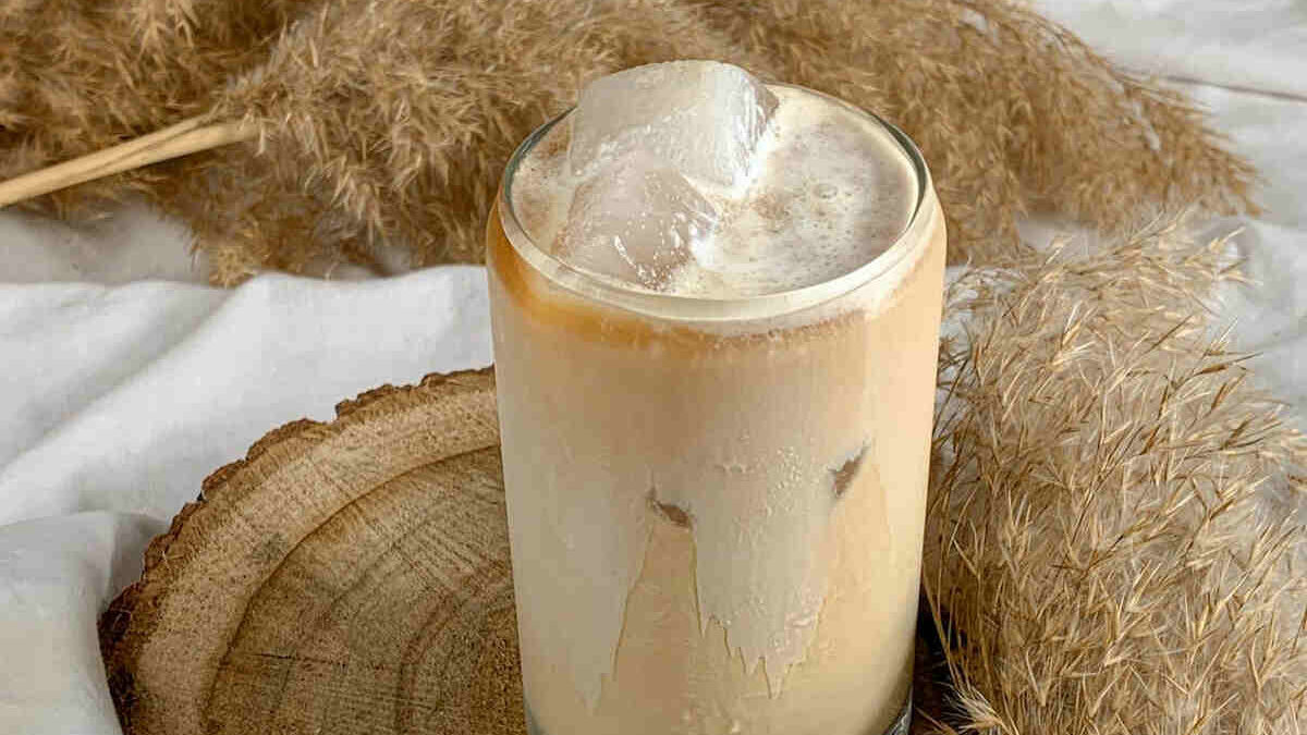 illustrating Summer on Ice with a glass of creamy iced coffee with artistic background