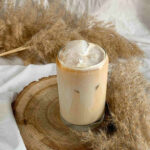 illustrating Summer on Ice with a glass of creamy iced coffee with artistic background