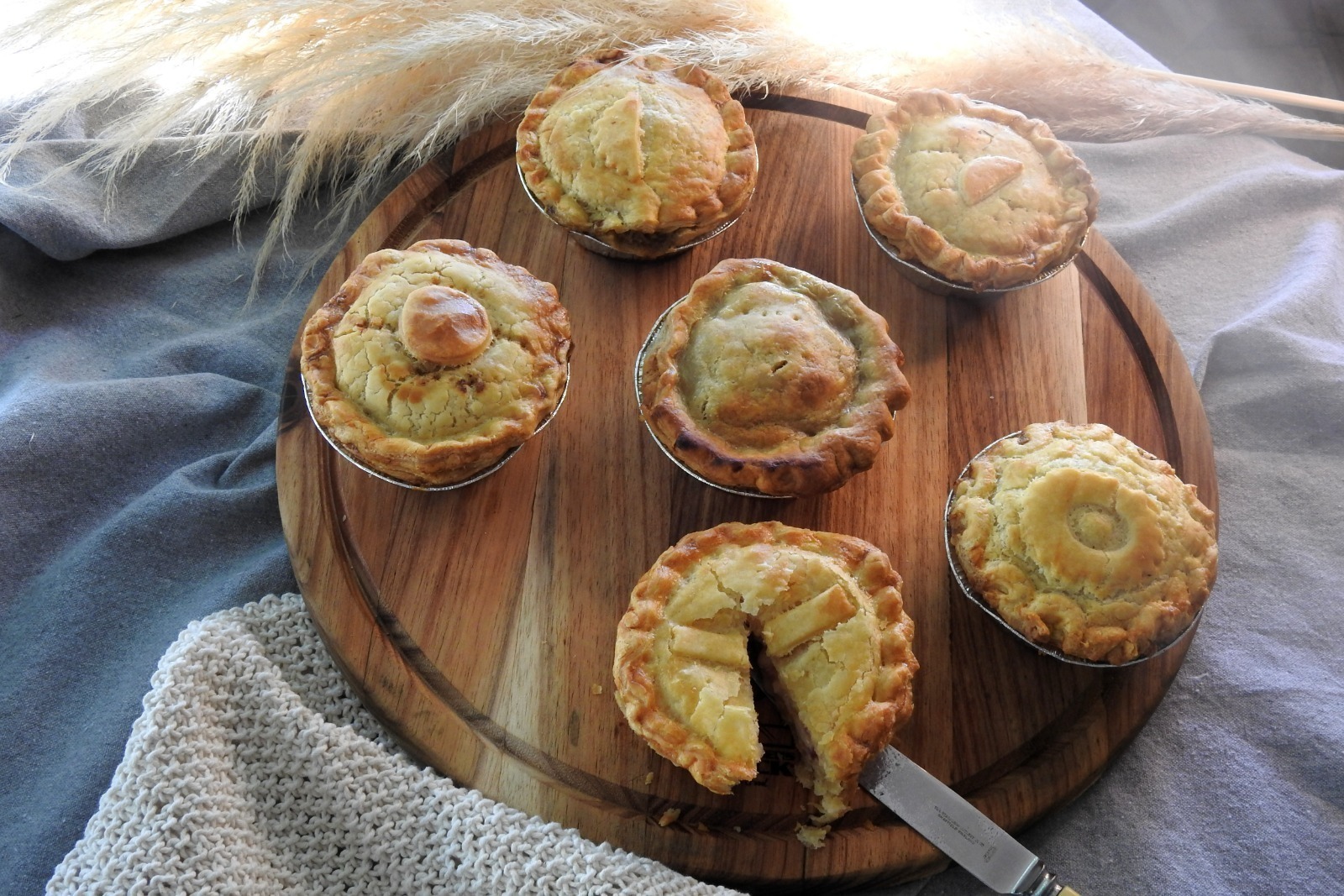 A featured food image of a freshly baked filled pie with crisp golden pastry and a hearty gravy filling, captured in bright natural light that highlights its texture and inviting, freshly made appearance.