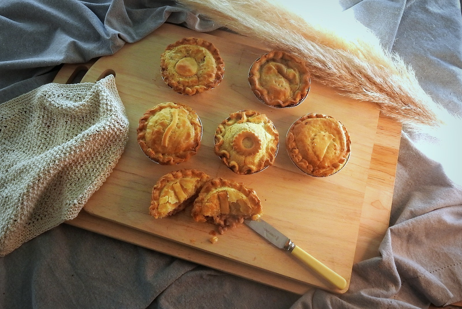 Pies with golden flaky pastry and a rich meat and vegetable filling,shown in bright natural light that enhances its fresh, hearty appeal.