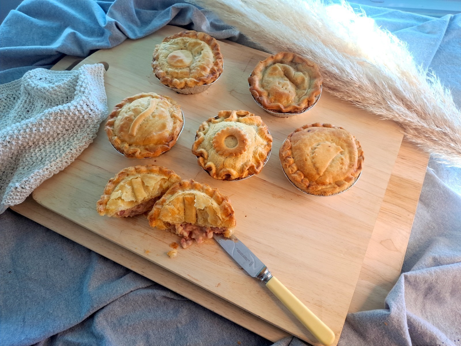 A deeply baked farmhouse-style pie with a rich brown crust and generous filling, captured in soft low lighting that enhances its rustic depth and bold satisfying flavour.
