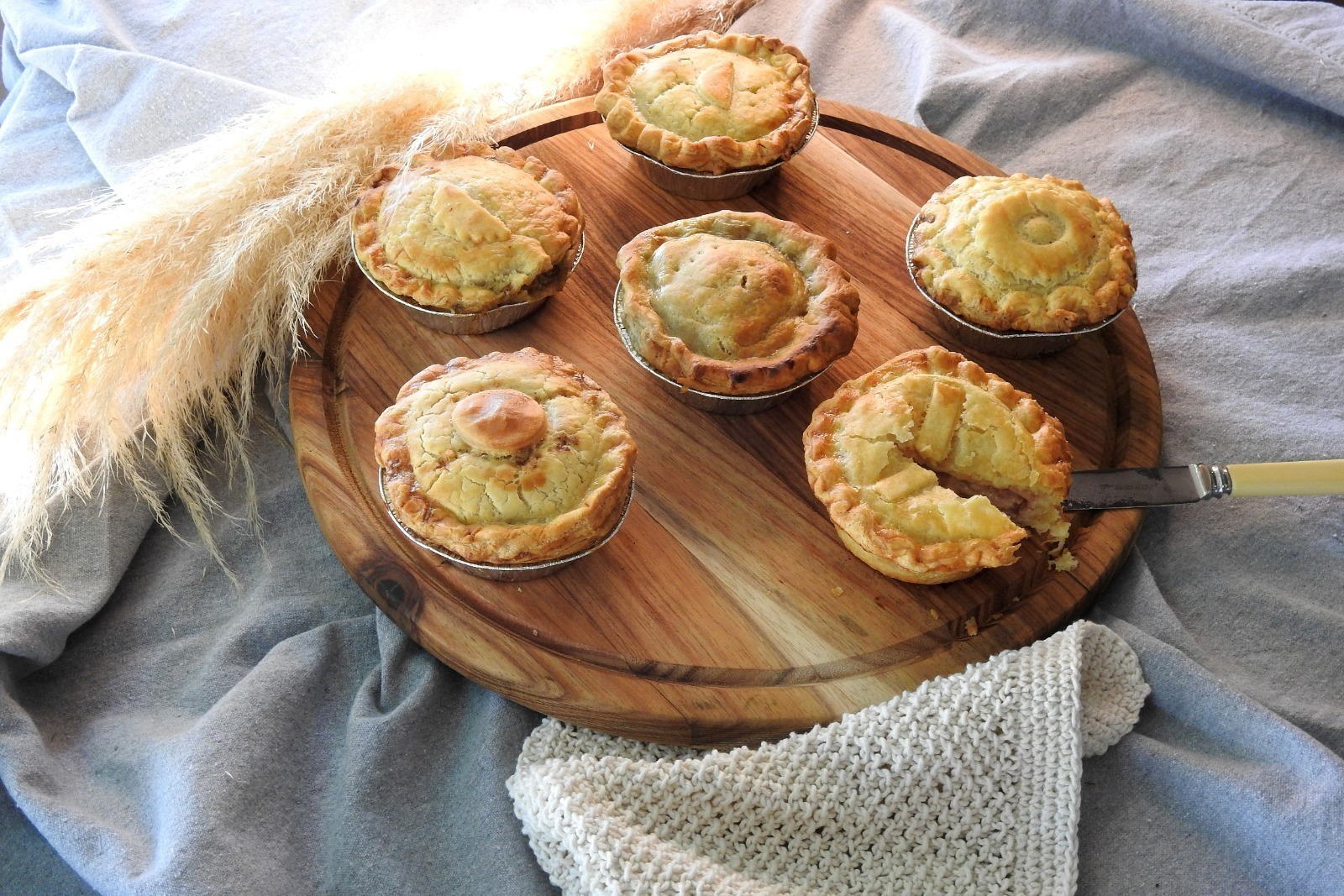 A rustic pie with a perfectly baked golden crust and rich savoury filling, shown in natural daylight that brings out its earthy charm and appetising colour.