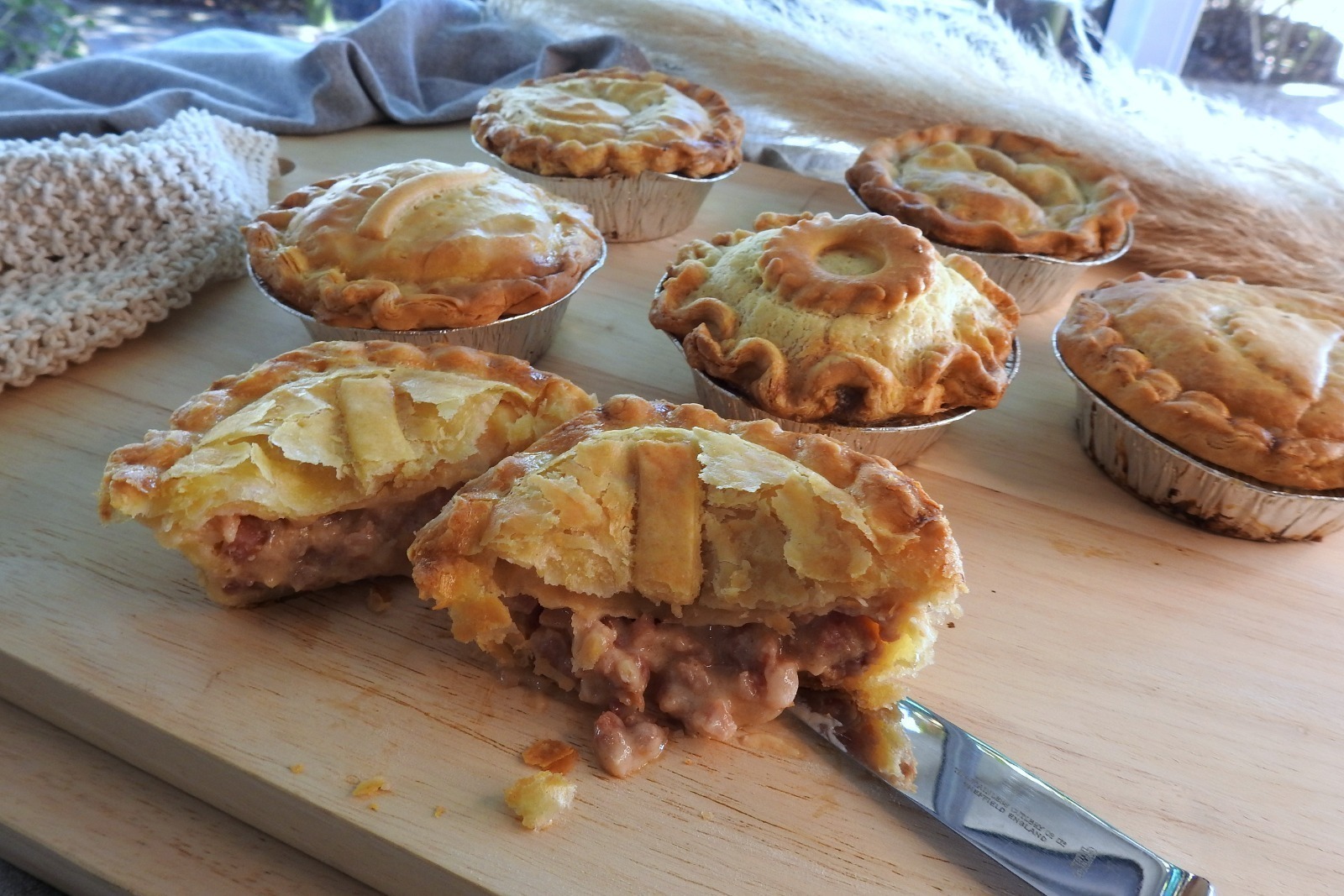 Savoury pie with rich gravy filling and flaky pastry, captured in natural daylight that streams across the table, emphasizing freshness.