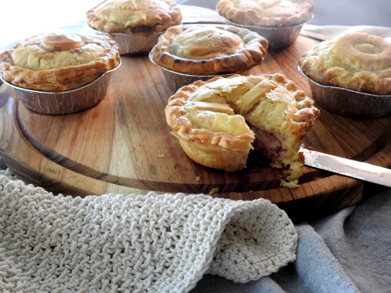 A classic baked pie with a dark golden crust and thick slow-cooked filling, presented in warm dim lighting that creates a rich, comforting and hearty feel.