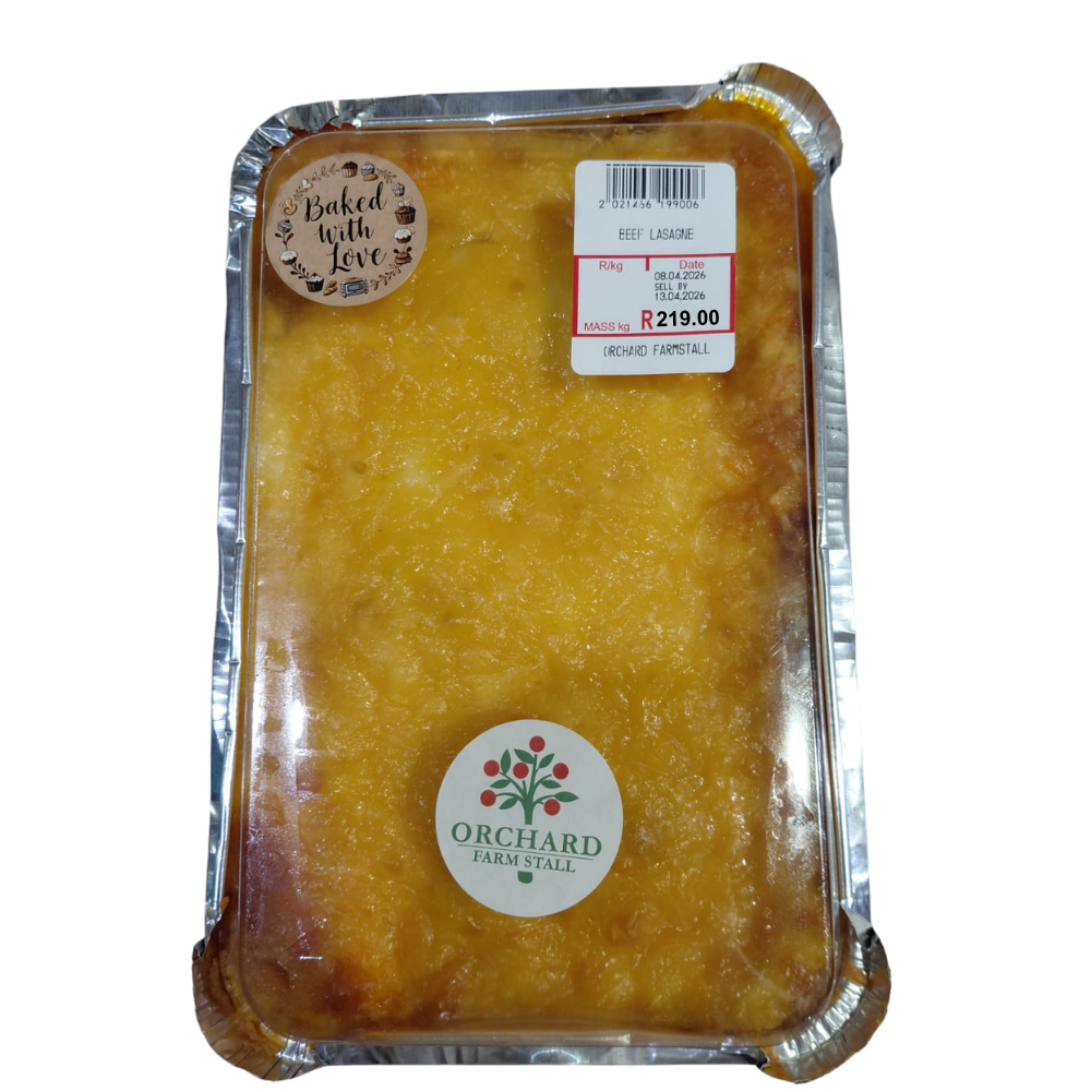 A close-up image of a baked pasta dish in its packaging, showing layers of rich meat sauce, creamy sauce, and melted cheese, baked to a golden finish and ready for a comforting meal.