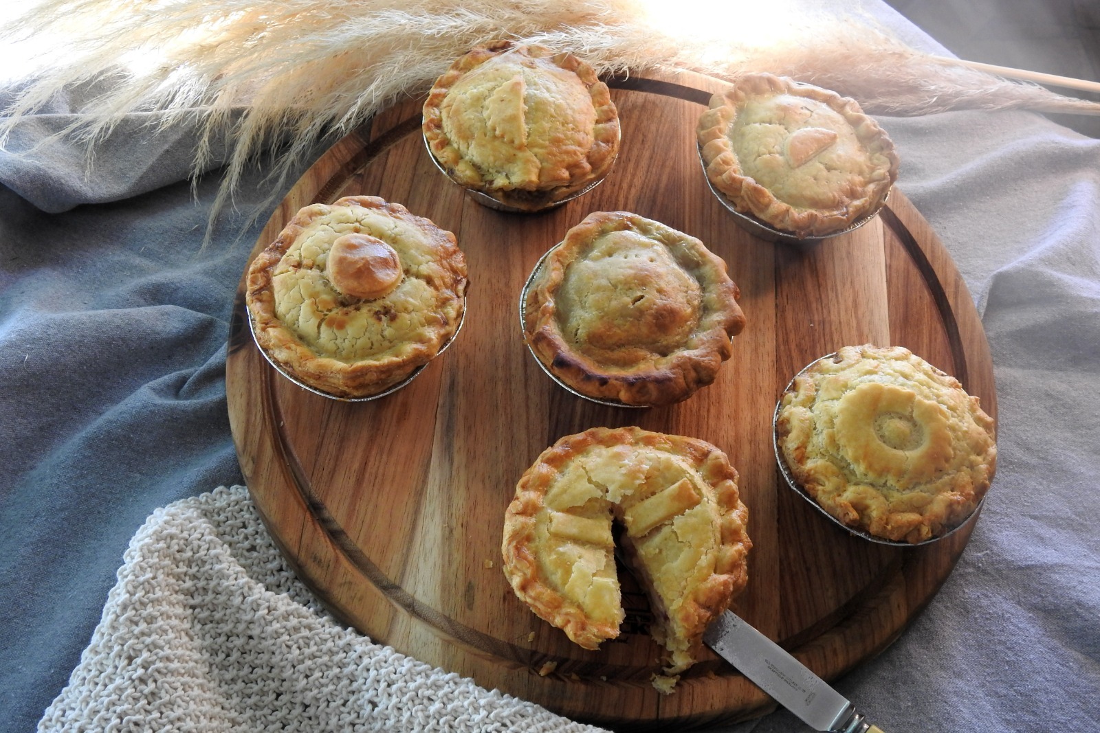A featured food image of a freshly baked filled pie with crisp golden pastry and a hearty gravy filling, captured in bright natural light that highlights its texture and inviting, freshly made appearance.