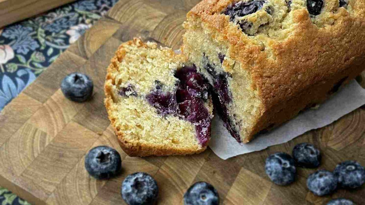 7 best easter recipes with a blueberry loaf on a bread board beside eggs and blueberries