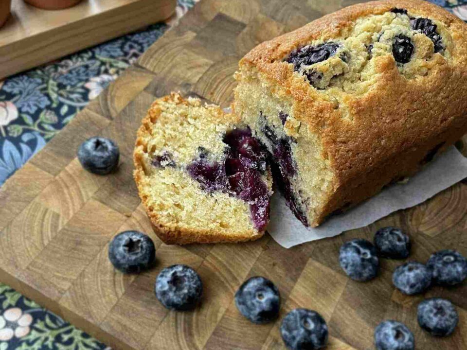 7 best easter recipes with a blueberry loaf on a bread board beside eggs and blueberries