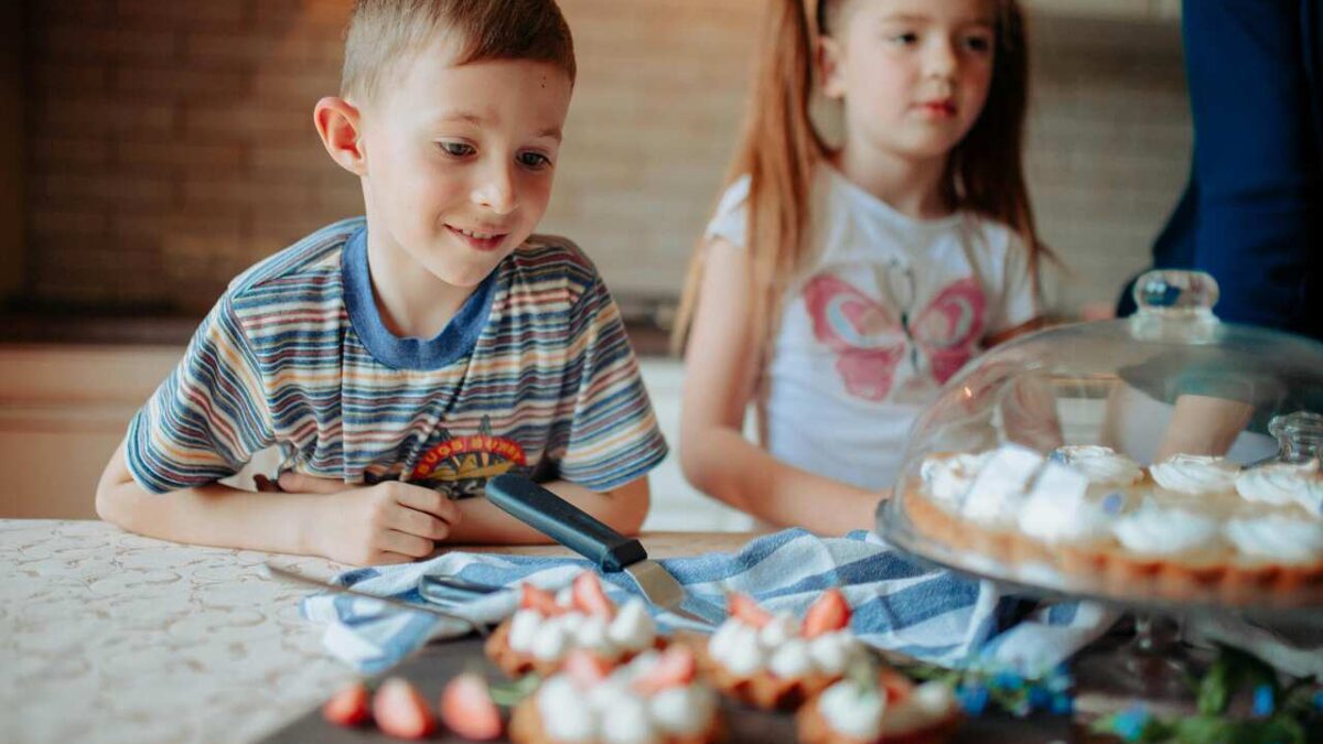 Kids baking simple desserts in a farm kitchen with fresh ingredients
