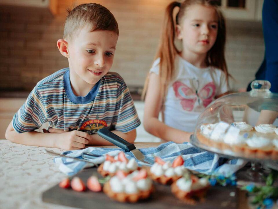 Kids baking simple desserts in a farm kitchen with fresh ingredients