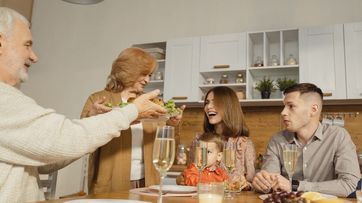 Multiple generations of a family sharing a meal around a dining table.