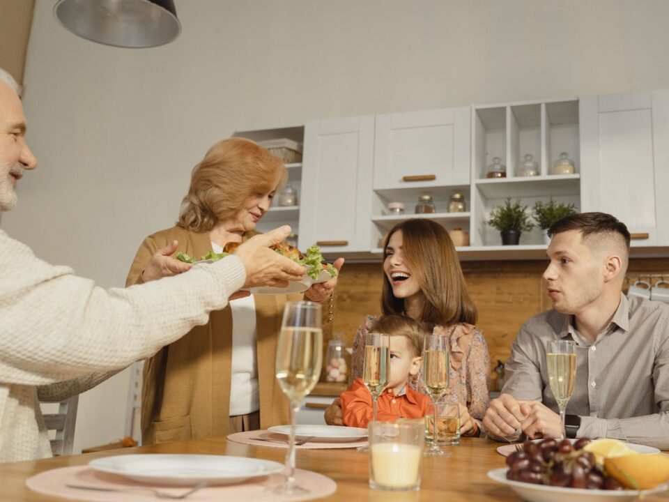 Multiple generations of a family sharing a meal around a dining table.