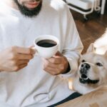 Dog relaxing beside its owner at an outdoor table with coffee and homemade baked treats at The Orchard Farm Stall in the Elgin Valley.