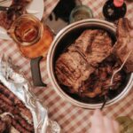Homemade braai side dishes including creamy potato bake, stuffed mushrooms and roasted vegetables served with grilled meat