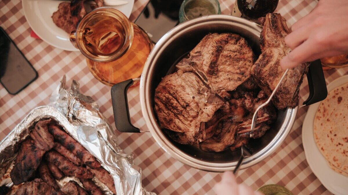 Homemade braai side dishes including creamy potato bake, stuffed mushrooms and roasted vegetables served with grilled meat