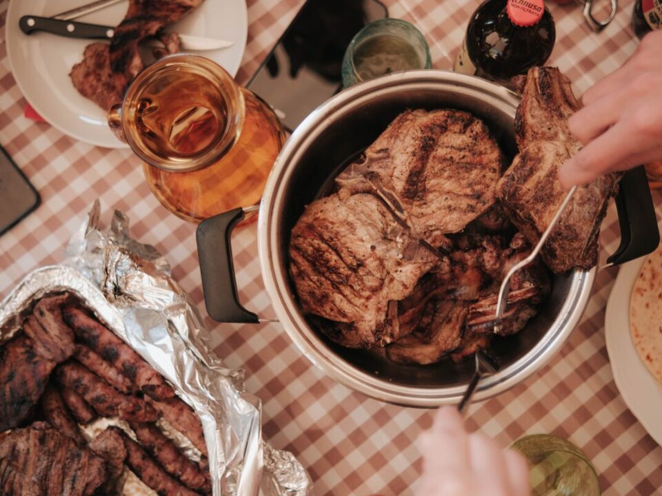 Homemade braai side dishes including creamy potato bake, stuffed mushrooms and roasted vegetables served with grilled meat