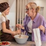 Family baking strawberry muffins together at home
